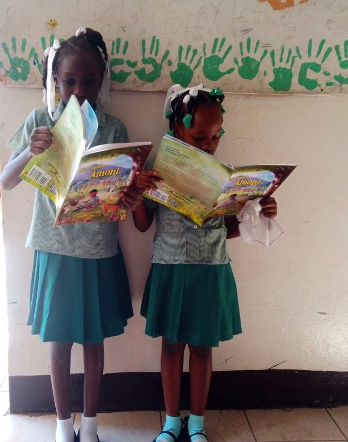 A young reader smiling with Nan Jaden Amoni