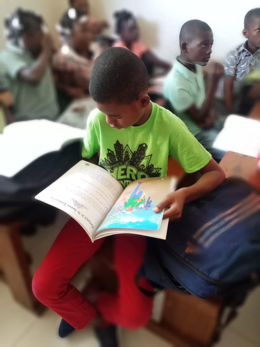 A boy proudly holding the Nan Jaden Amoni book